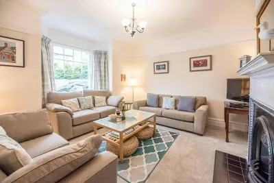 a living room with couches and a fireplace at Pebble House, Aldeburgh in Aldeburgh