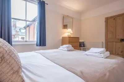 a bedroom with two beds with white sheets and a window at Pebble House, Aldeburgh in Aldeburgh