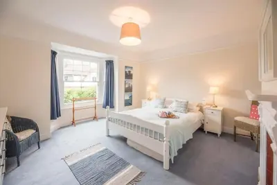 a bedroom with a white bed and a window at Pebble House, Aldeburgh in Aldeburgh