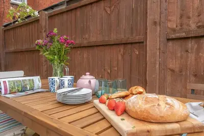 a table with a loaf of bread and strawberries on it at Pebble House, Aldeburgh in Aldeburgh