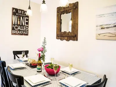 a dining room table with a mirror on the wall at Cannon Corner by The Suffolk Cottage Collection in Aldeburgh