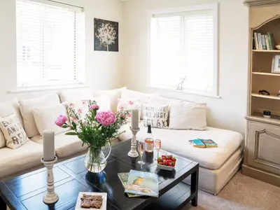 a living room with a white couch and a coffee table at Cannon Corner by The Suffolk Cottage Collection in Aldeburgh