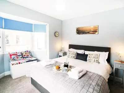 a bedroom with a bed with a tray of food on it at Cannon Corner by The Suffolk Cottage Collection in Aldeburgh