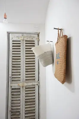 a basket is hanging on a wall next to a door at The Skyroom in Rendham