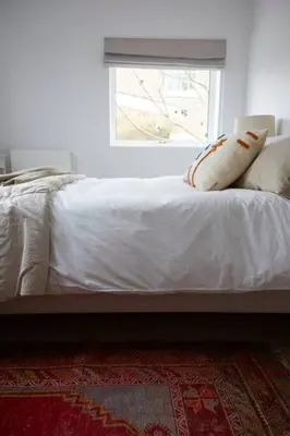 a bed with white sheets and pillows and a window at The Skyroom in Rendham