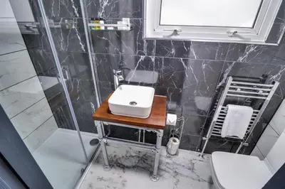 a bathroom with a sink and a shower at Studio Apartments in Southend in Southend-on-Sea
