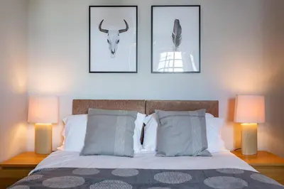 a bedroom with a bed with two lamps on it at St Johns Apartments & Studios Southend in Southend-on-Sea