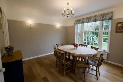 a dining room with a table and chairs and a window at Exquisite location close to the sea! in Frinton-on-Sea