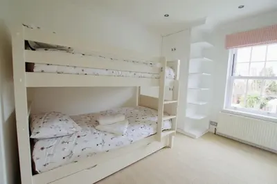 a bedroom with two bunk beds and a window at Exquisite location close to the sea! in Frinton-on-Sea