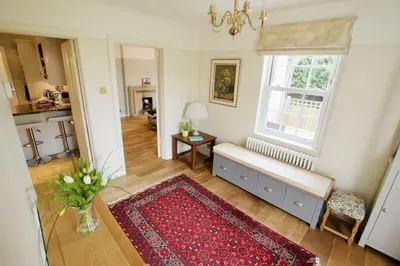 a living room with a bench and a window at Exquisite location close to the sea! in Frinton-on-Sea