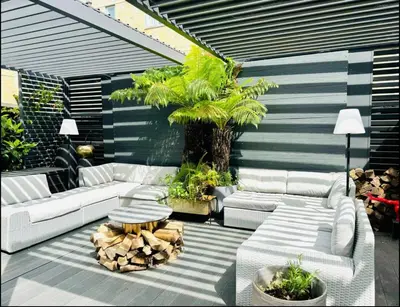 a patio with white couches and a palm tree at Stunning designer House in excellent city location in Cambridge
