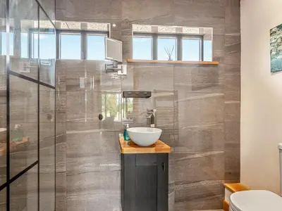 a bathroom with a sink and a shower at Gladwyns Farm Lodge in Thaxted