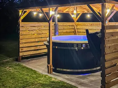 a large hot tub in a backyard at night at Gladwyns Farm Lodge in Thaxted