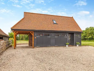 a large garage with a brown roof at Gladwyns Farm Lodge in Thaxted