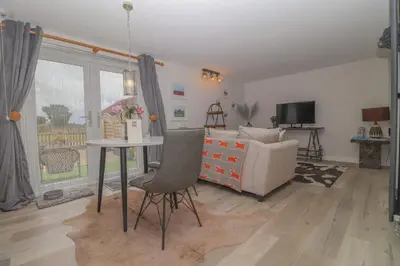 a living room with a table and a couch at Charming dog friendly cottage in rural Suffolk in Eye