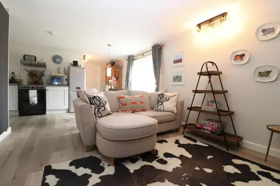 a living room with a couch and a chair at Charming dog friendly cottage in rural Suffolk in Eye