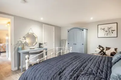 a bedroom with a bed and a desk and a mirror at Charming dog friendly cottage in rural Suffolk in Eye