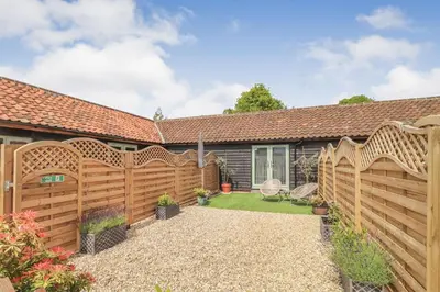 a wooden fence in front of a house at Charming dog friendly cottage in rural Suffolk in Eye