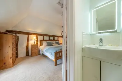 a bathroom with a bed and a sink in a room at Rural perfection in Constable Country - Beachams Cottage in Colchester