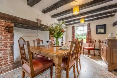 a dining room with a wooden table and chairs at Rural perfection in Constable Country - Beachams Cottage in Colchester