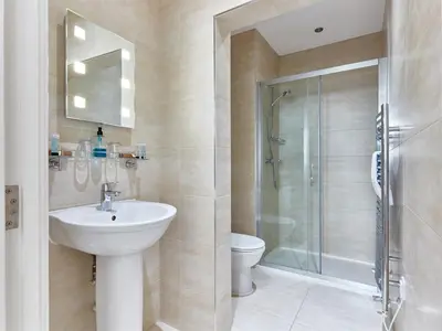 a bathroom with a sink and a shower and a toilet at Beaches Guest House in Southend-on-Sea
