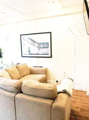 a living room with a couch and a picture on the wall at Spacious 4-Bedroom Home, Sleeps 7, Family & Professional Friendly, Clark Property Estates in Southend-on-Sea