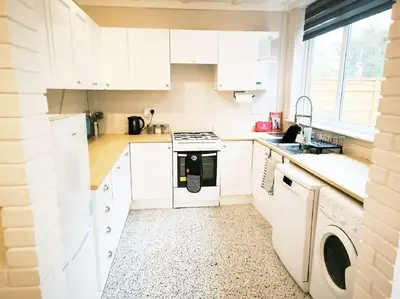 a kitchen with white cabinets and a dishwasher at Spacious 4-Bedroom Home, Sleeps 7, Family & Professional Friendly, Clark Property Estates in Southend-on-Sea