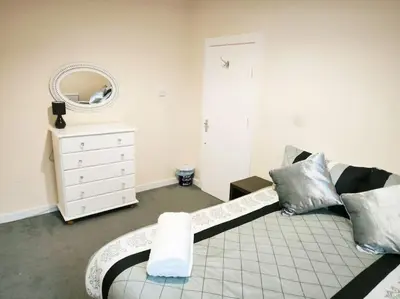 a living room with a couch and a mirror at Spacious 4-Bedroom Home, Sleeps 7, Family & Professional Friendly, Clark Property Estates in Southend-on-Sea