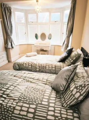 a bedroom with two beds and a window at Spacious 4-Bedroom Home, Sleeps 7, Family & Professional Friendly, Clark Property Estates in Southend-on-Sea