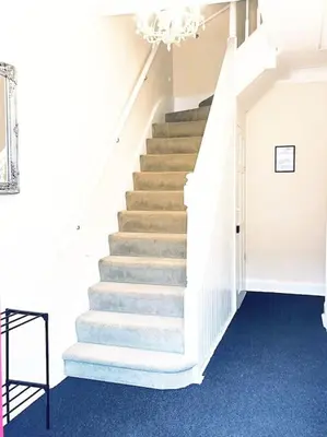 a staircase in a building with a chandelier at Spacious 4-Bedroom Home, Sleeps 7, Family & Professional Friendly, Clark Property Estates in Southend-on-Sea