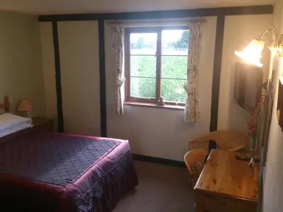 a bedroom with a bed and a window and a table at Six Bells Inn in Bardwell