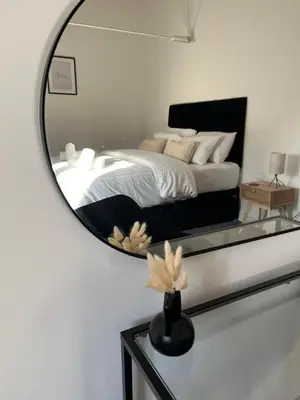 a mirror in a bedroom with a bed at 3 Bed Barn in Cambridge next to Anglesey Abbey in Cambridge