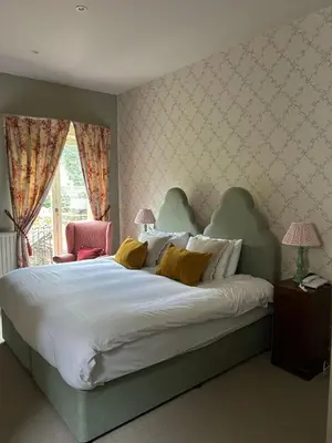 a bedroom with a large white bed with yellow pillows at Ravenwood Hall Hotel in Bury Saint Edmunds