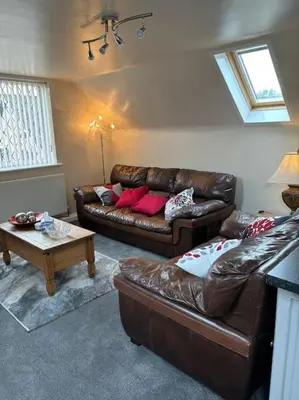 a living room with two leather couches and a table at A great country escape in Hockwold cum Wilton