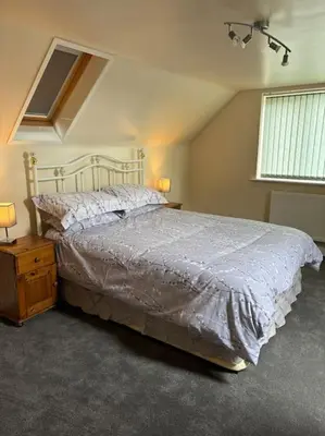 a bedroom with a large bed and a window at A great country escape in Hockwold cum Wilton
