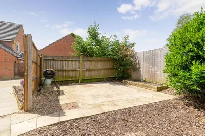 a backyard with a wooden fence and a patio at Entire House - Contractor's, Families & More in Little Wymondley