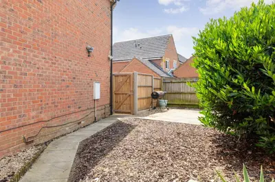a brick building with a gate and a fence at Entire House - Contractor's, Families & More in Little Wymondley