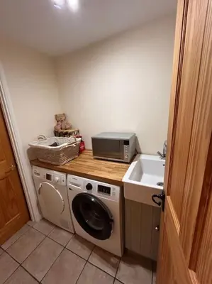 a kitchen with a washing machine and a sink at Cottage K in Hinxton