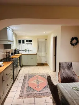 a kitchen with a table and chairs in a room at Cottage K in Hinxton