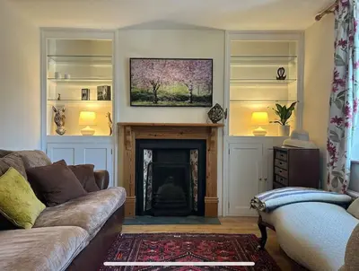 a living room with a couch and a fireplace at Cottage K in Hinxton