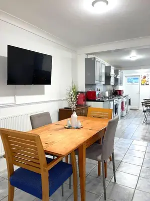 a kitchen with a wooden dining table and chairs at 12 Penn Gardens - Apart 1 in Friern Barnet