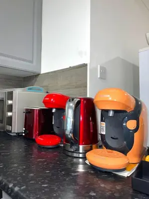 a kitchen counter with a row of coffeemakers at 12 Penn Gardens - Apart 1 in Friern Barnet