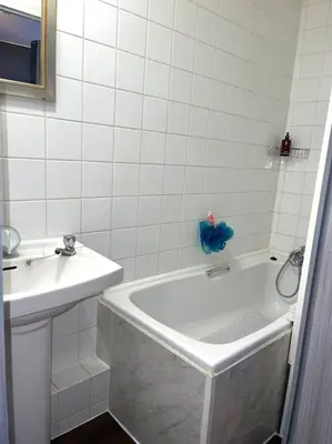 a white bathroom with a tub and a sink at 12 Penn Gardens - Apart 1 in Friern Barnet