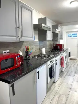 a kitchen with a red microwave on a counter at 12 Penn Gardens Standard Room- 4 in Friern Barnet