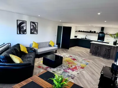 a living room with a couch and a kitchen at New 2 Bed Apartment in Royston High St in Royston