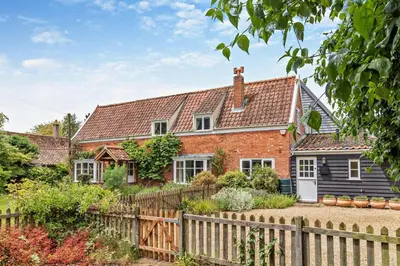 a brick house with a wooden fence at 3 Bed in Snape oc-g29478 in Snape