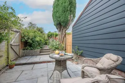 a patio with a table and chairs and a tree at Angel Cottage, Wenhaston in Halesworth