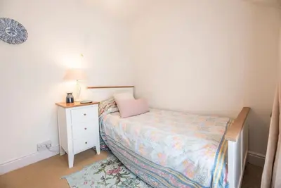 a small bedroom with a bed and a night stand at Angel Cottage, Wenhaston in Halesworth
