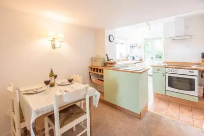 a kitchen and dining room with a table and a table and chairs at Angel Cottage, Wenhaston in Halesworth