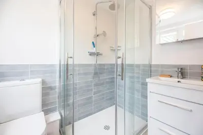 a bathroom with a shower and a toilet and a sink at Angel Cottage, Wenhaston in Halesworth